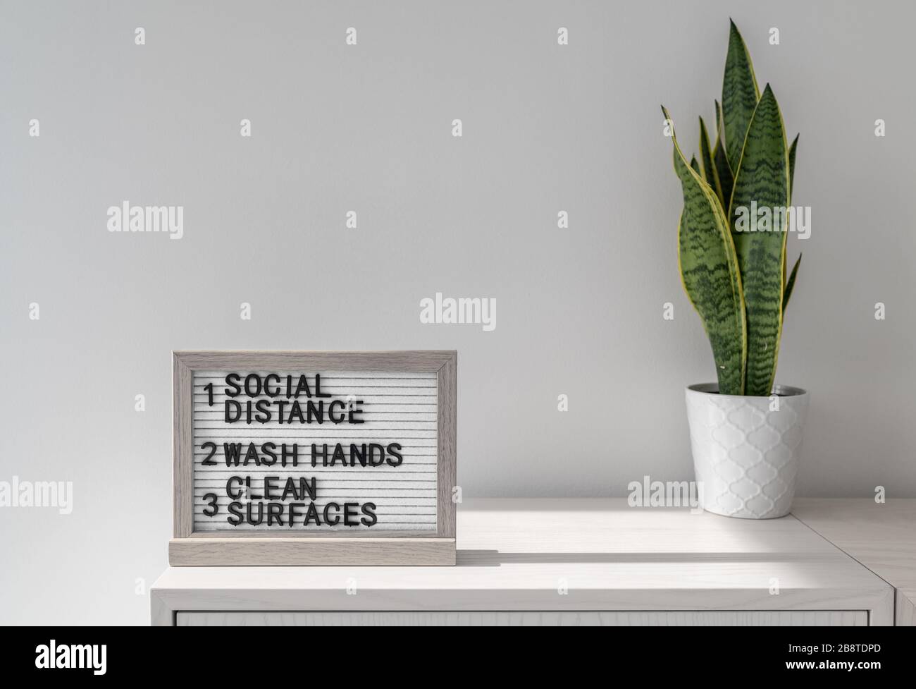 COVID-19 Coronavirus health safety guidelines. Text board in public space with rules, practice social distancing, wash hands often, clean surfaces Stock Photo