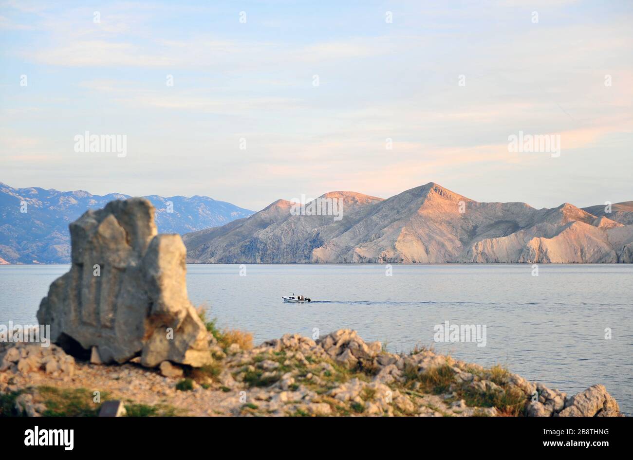 Speed boat, mountains and ancient letters monument on Krk island, Istria, Croatia Stock Photo