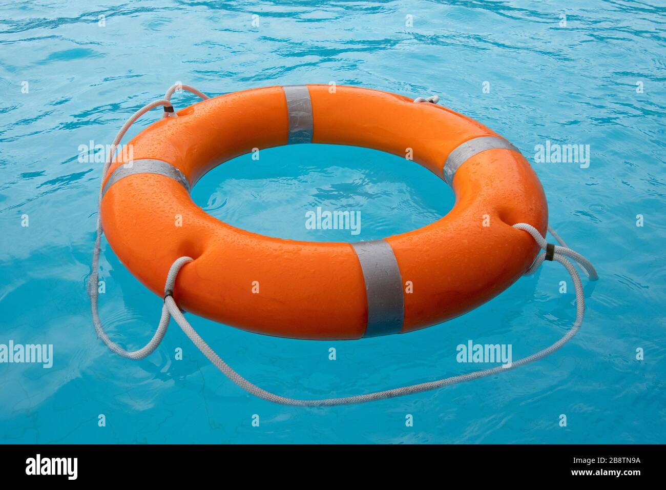 Orange lifebuoy in sea on water. Life ring floating on top of water. Life ring in ocean. Stock Photo
