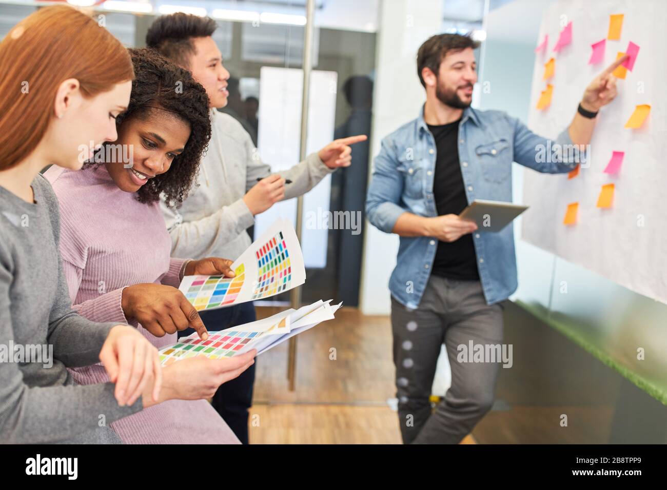 Creative start-up team brainstorming with sticky notes in a design agency Stock Photo