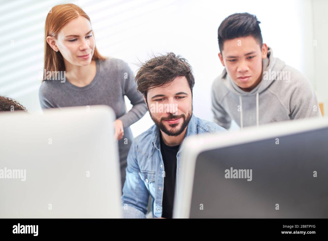 Together, web designers develop a design concept for a website on a PC Stock Photo