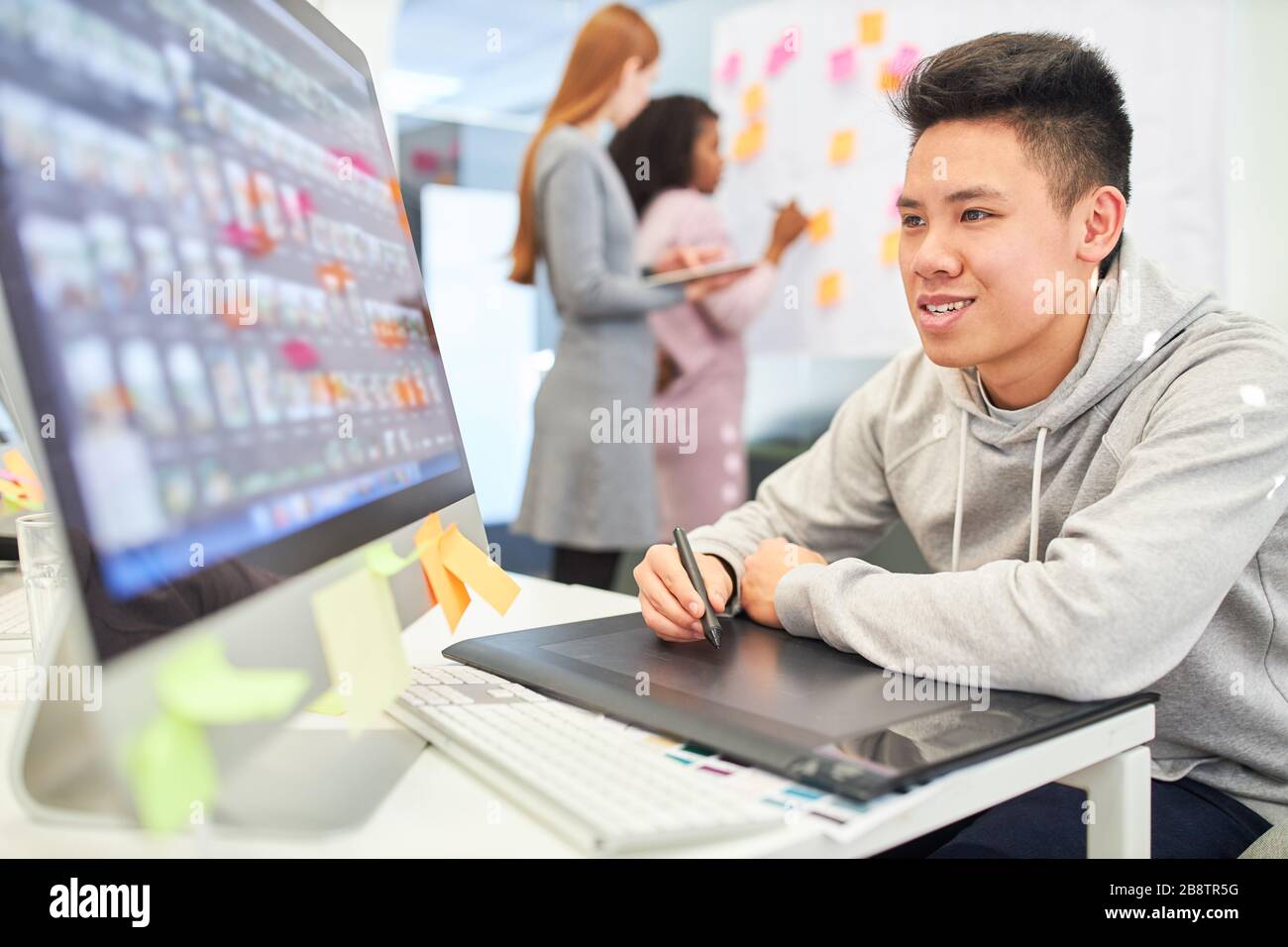Asian as a graphic designer with pen and tablet designs the layout for a website Stock Photo