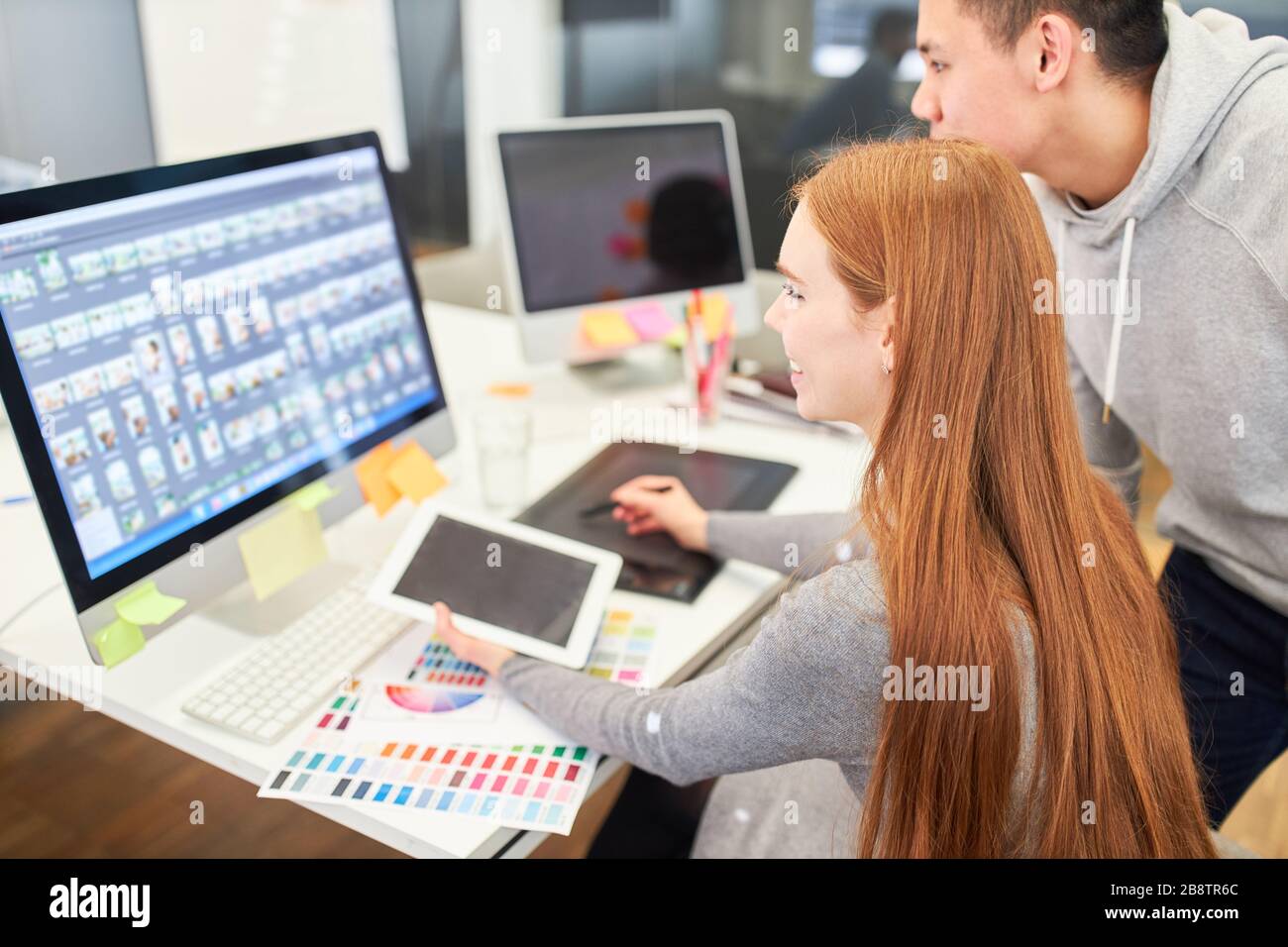 Woman as a web designer works with a web developer on a PC on a project Stock Photo
