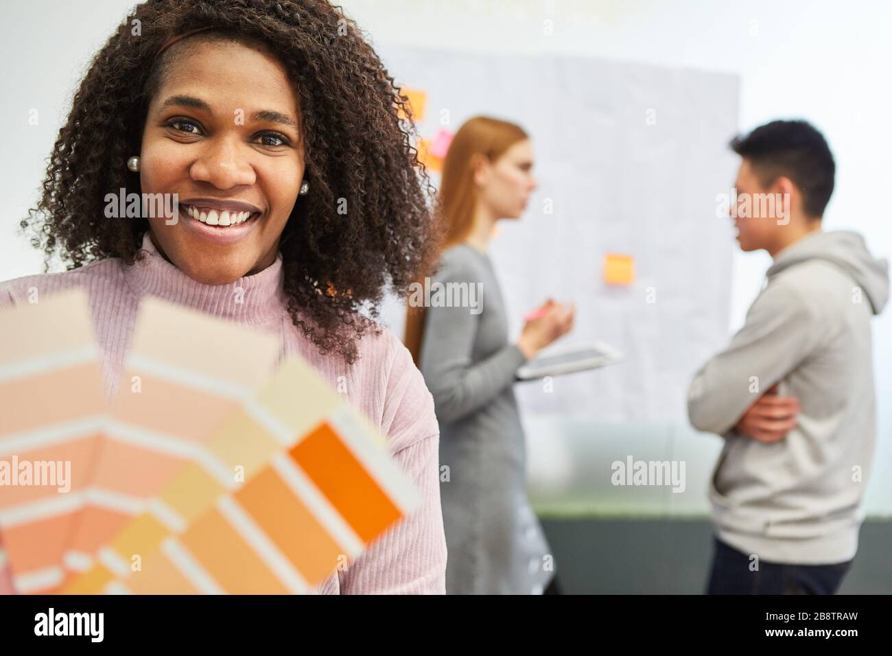 African woman as graphic designer with color palette for the color design of a website Stock Photo