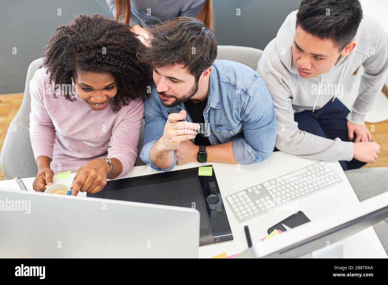 Web design team develops a design idea together on the computer in the office Stock Photo