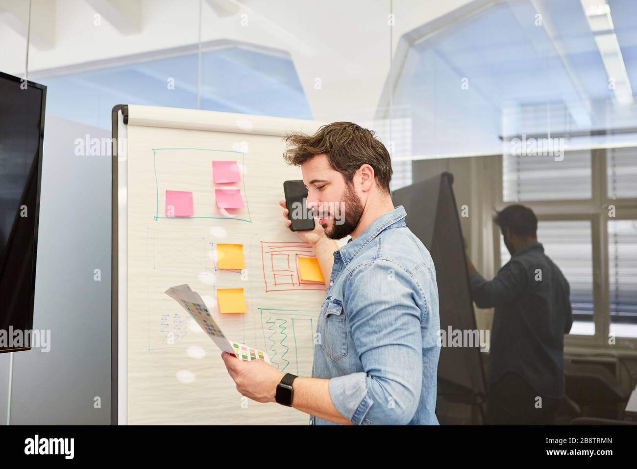 Graphic designer on the flipchart during the development of the design for a smartphone app Stock Photo