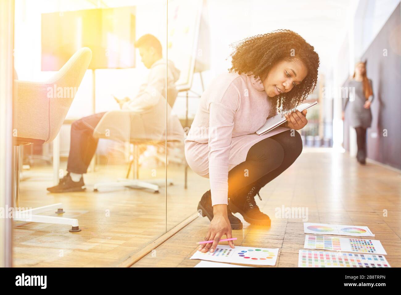 Woman as a web designer plans graphic design in the office with color palettes Stock Photo