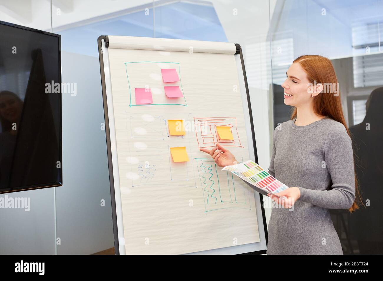 Young woman as graphic designer or speaker at a presentation on a flipchart Stock Photo
