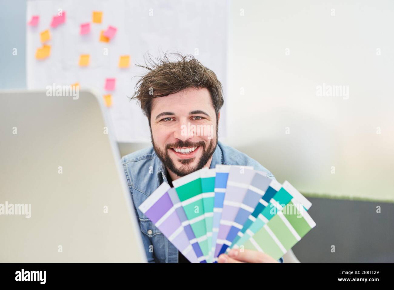 Man as a creative graphic designer with color samples for the color design of a website Stock Photo