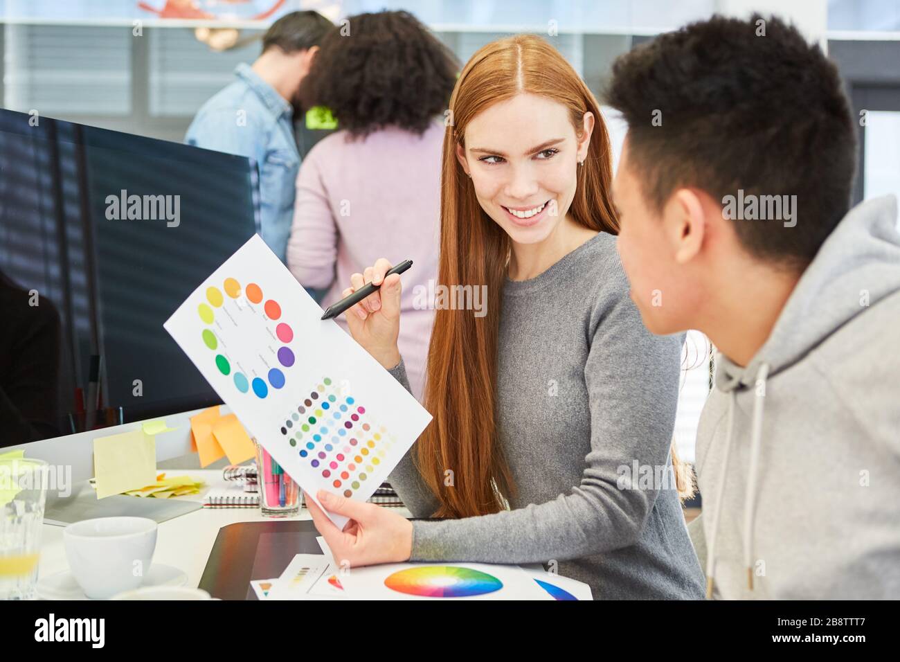 Young woman as a graphic designer with a color wheel has a suggestion for color design Stock Photo