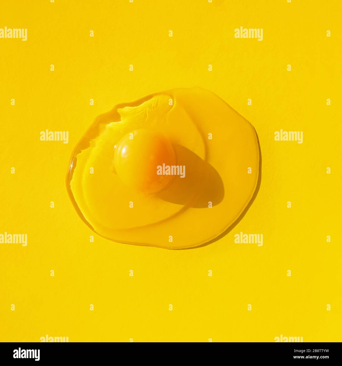 Raw egg on yellow background, top view. Stock Photo