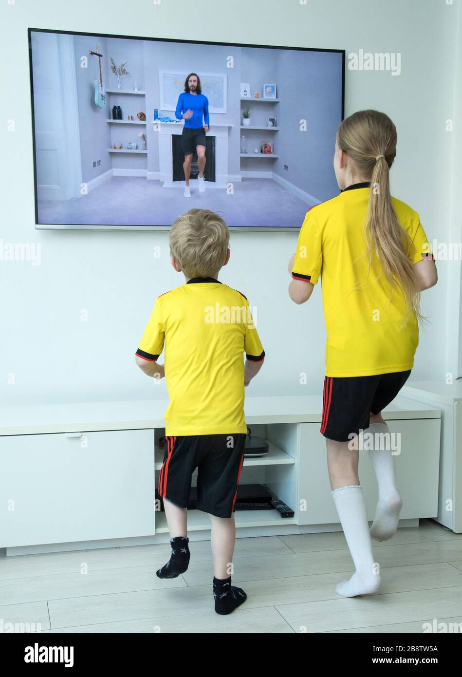 Mia, aged 8, and Jack, aged 5, take part in 'PE with Joe' a daily live workout with Joe Wicks on Youtube to help kids stay fit who have to stay indoors due to the Corona virus outbreak.Picture date: Monday March 23, 2020. Photo credit should read: Ian West/PA Wire Stock Photo