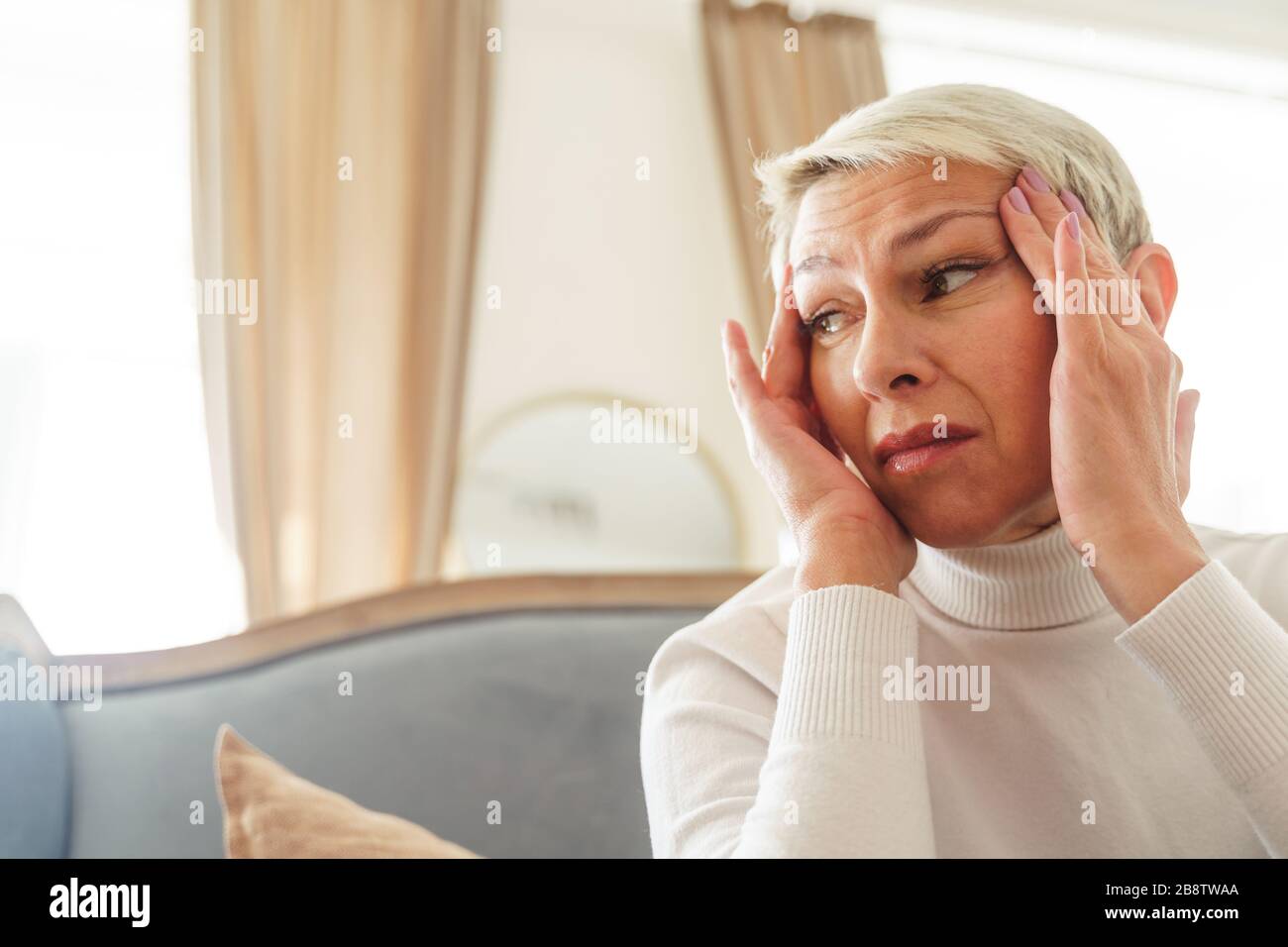 Sad elderly lady suffering from a headache Stock Photo
