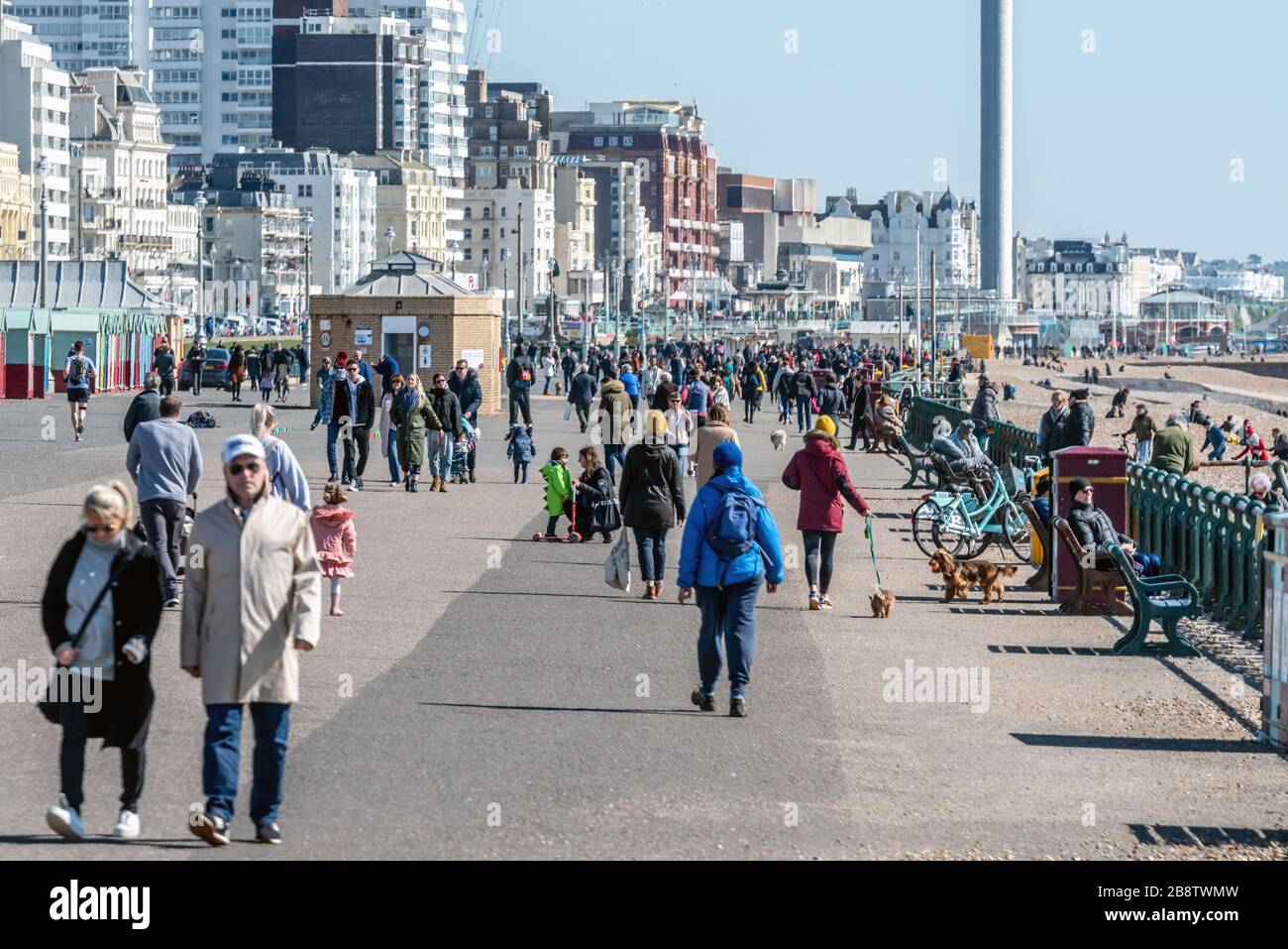 Crowds of people ignoring the government's advice on self-isolation by strolling along Hove seafront this morning. Stock Photo