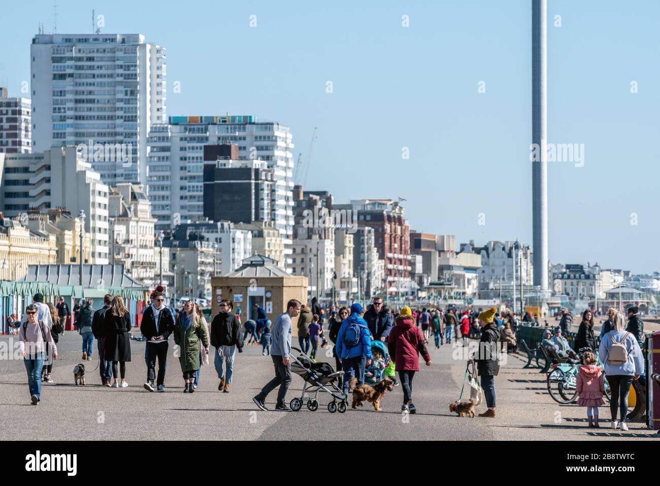 Crowds of people ignoring the government's advice on self-isolation by strolling along Hove seafront this morning. Stock Photo