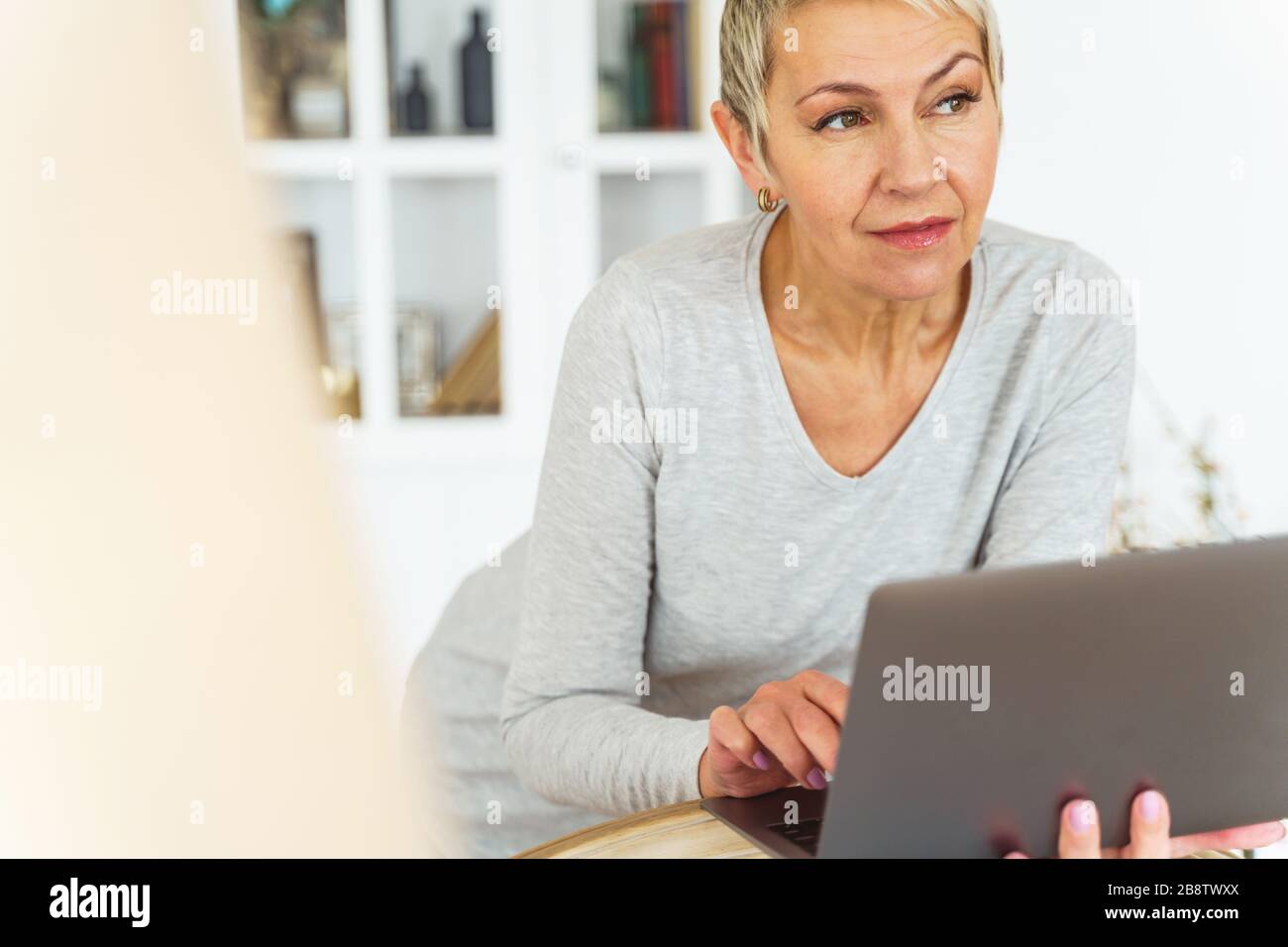 Serene aged short-haired Caucasian woman looking away Stock Photo