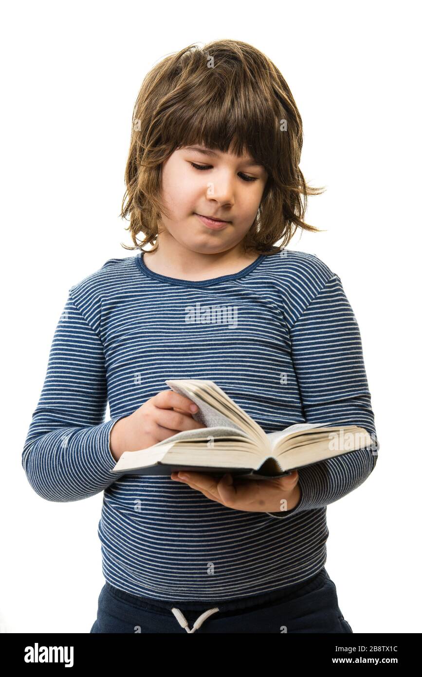 Seven years old boy reading a book isolated on white background Stock