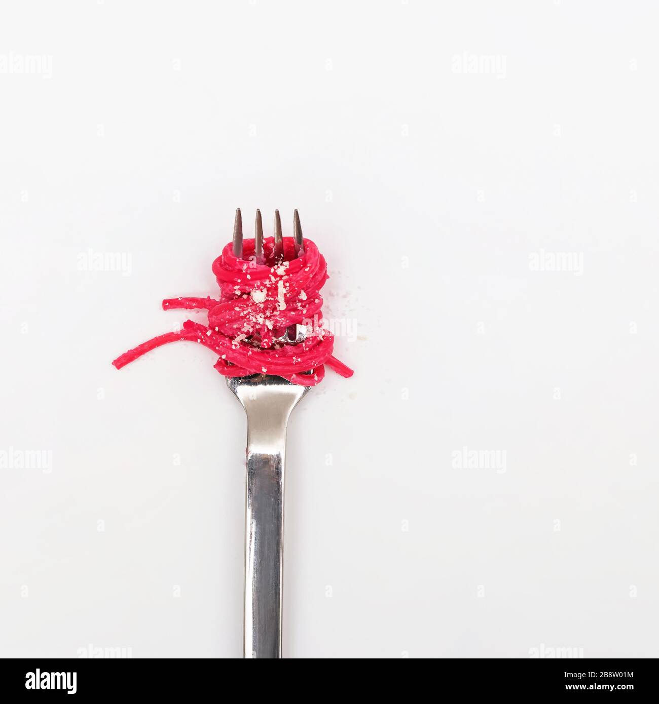 Spaghetti pasta with pink beetroot sause on a fork Stock Photo