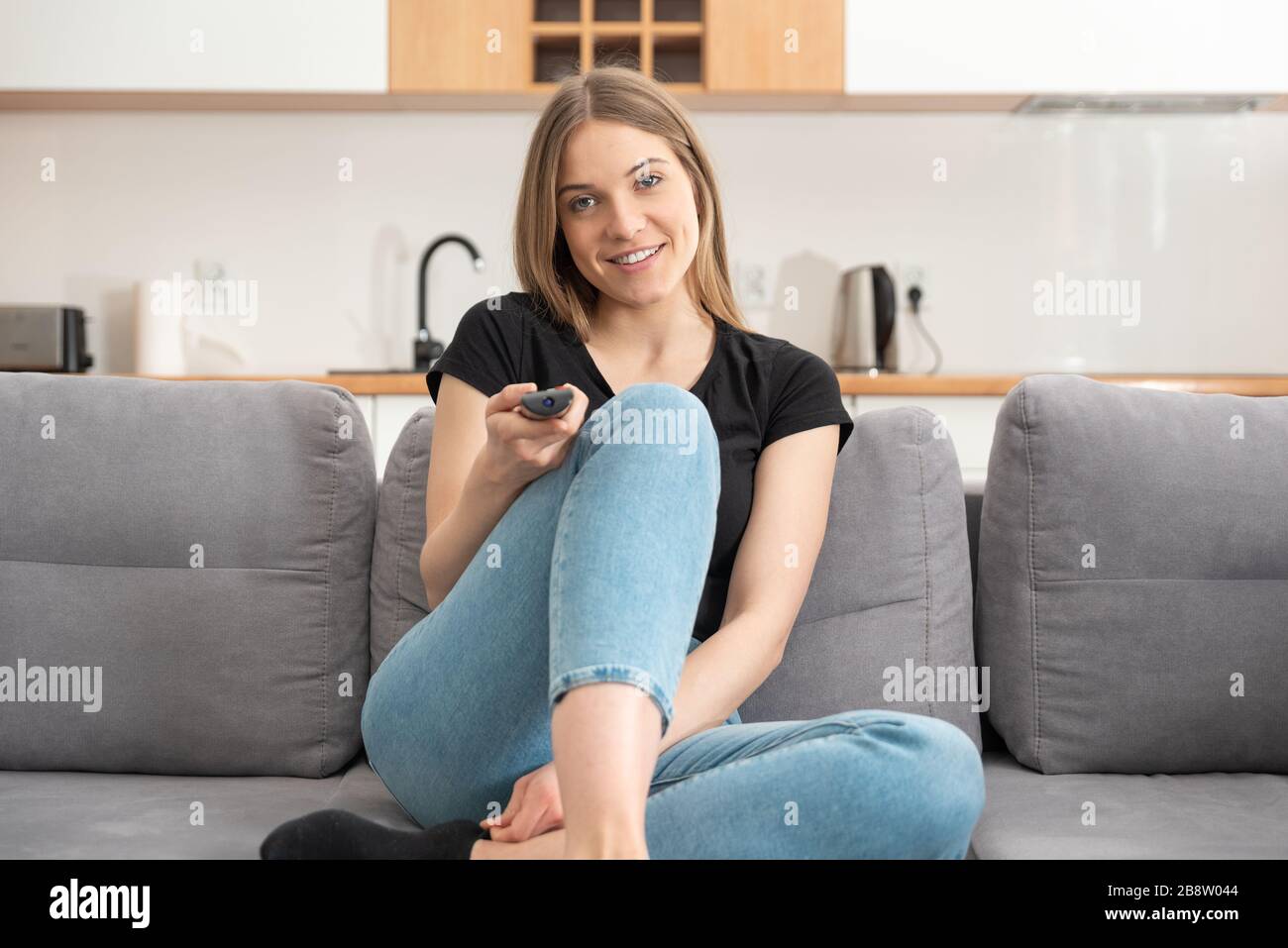 Woman watching TV on sofa in living room. Watching TV series Stock Photo