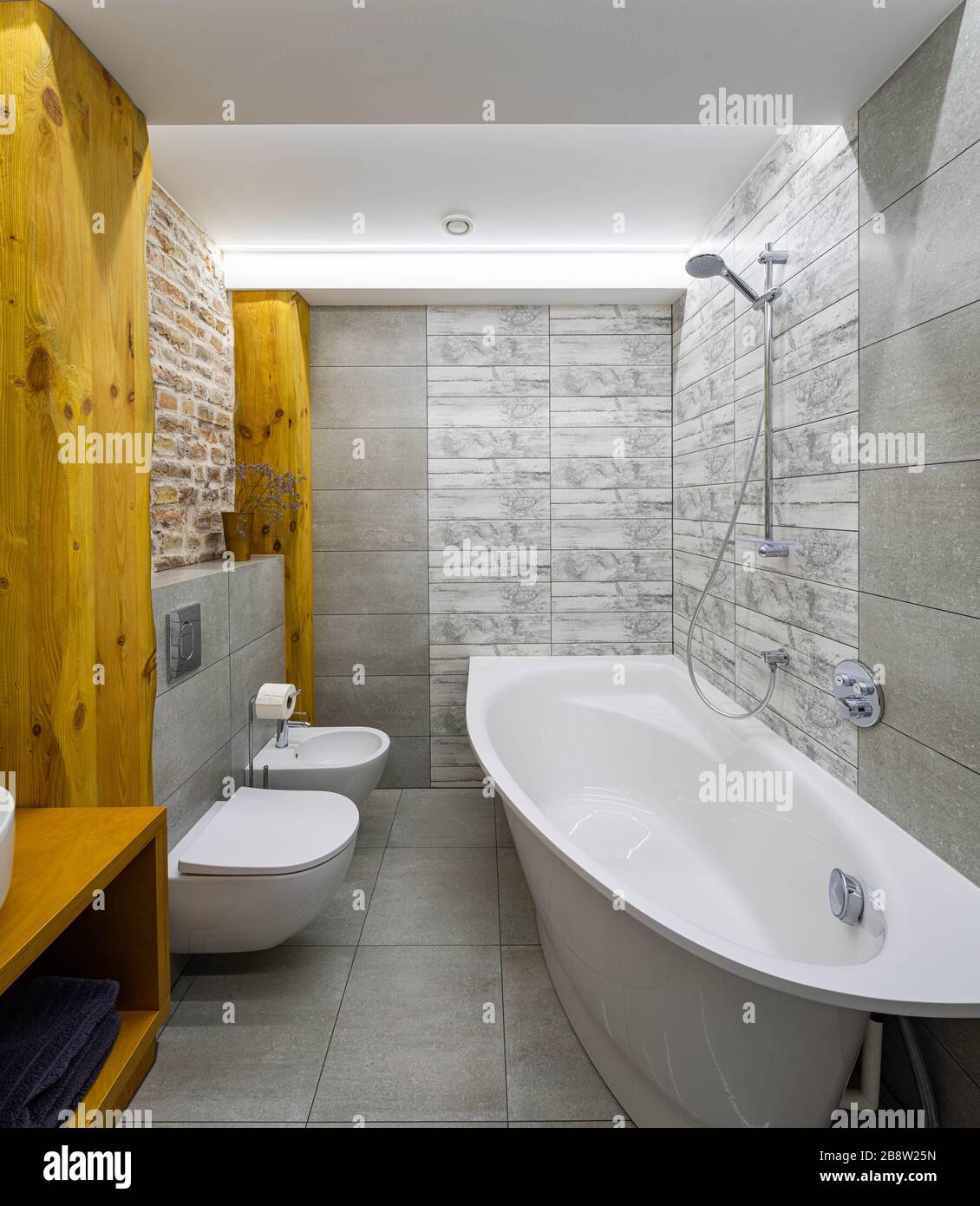 Modern loft interior of bathroom. Brick wall. Wooden design. Gray tile