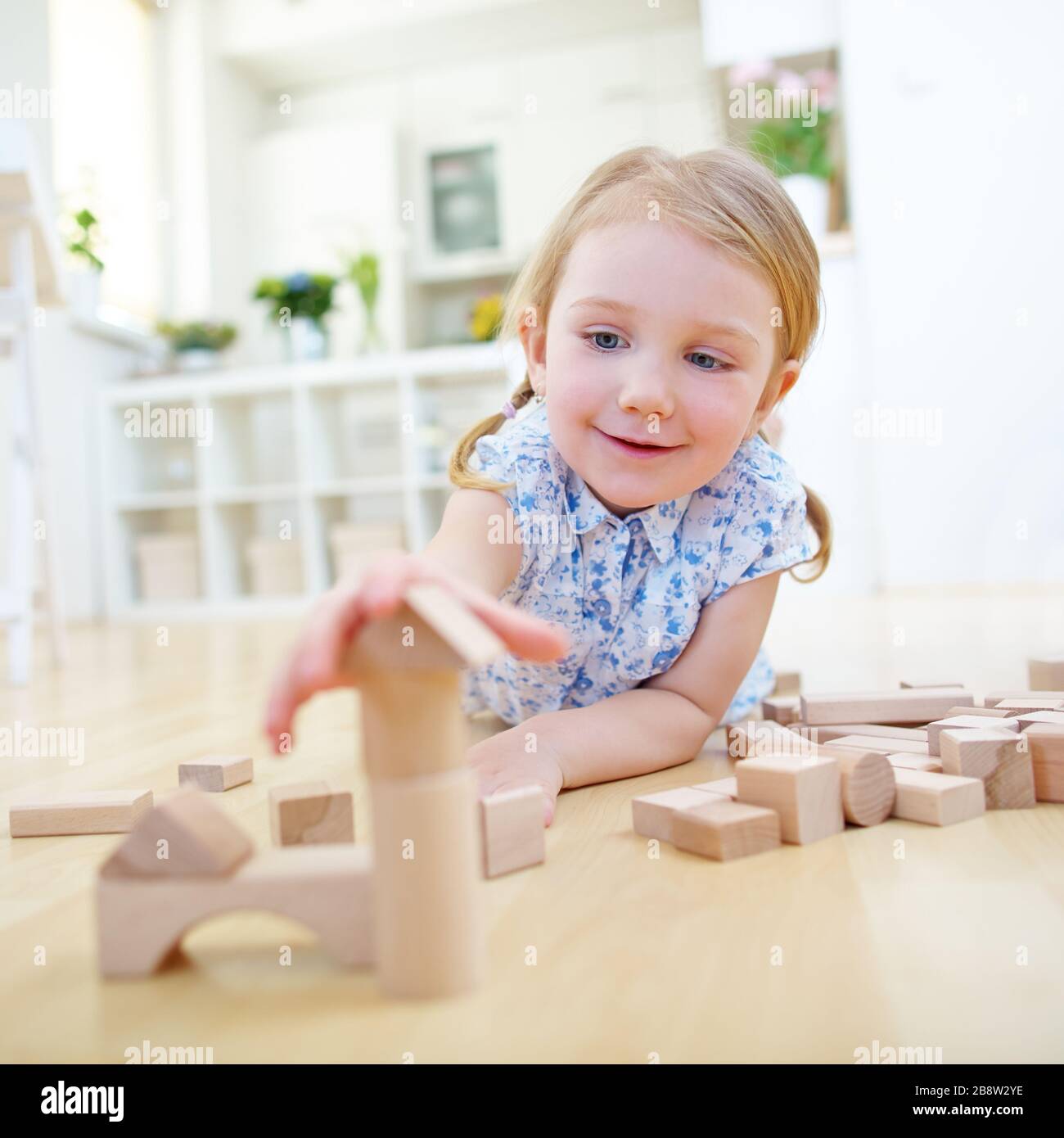 Child builds house with wooden building blocks at home Stock Photo Alamy