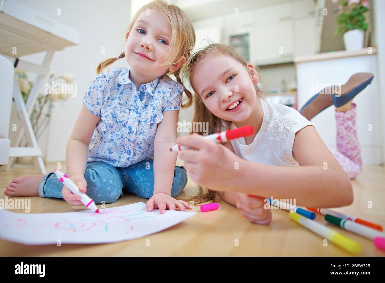 Children paint picture with felt pen on the floor at home Stock Photo