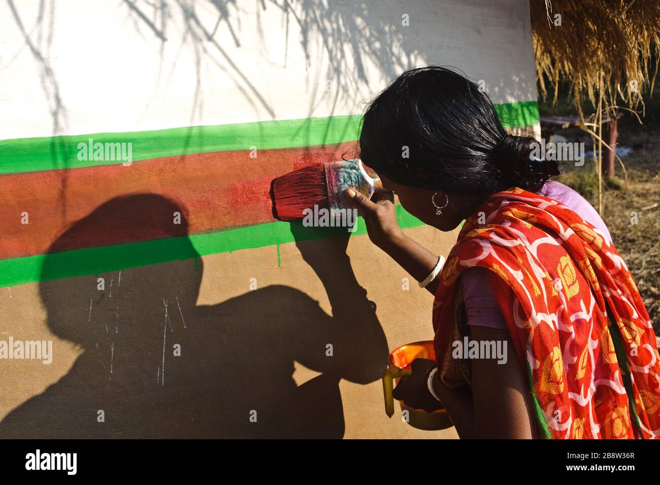 Tribal woman painting a house ( India) Stock Photo
