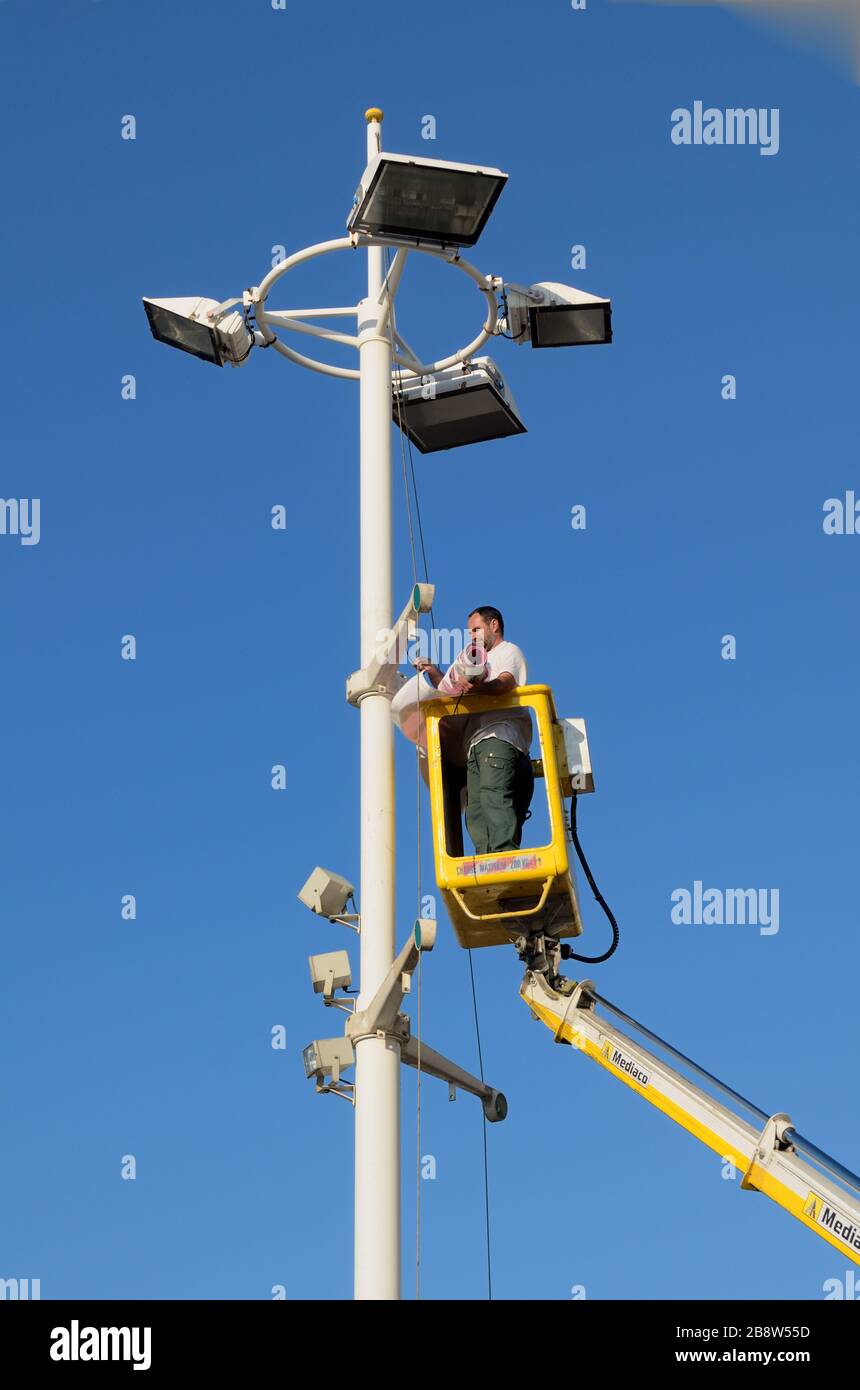 Worker Working from Aerial Work Platform (AWP) aka Boom Lift, Lift Machine, Aerial Device, Elevating Work Platform (EWP) or Bucket Truck Stock Photo