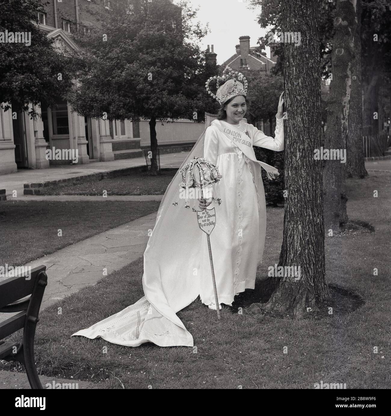 1960s, historical, standing outside, the excited and newly crowned London May Queen, a young teenage girl wearing her gown and tiara, Lewisham, South East London, England, UK. Stock Photo