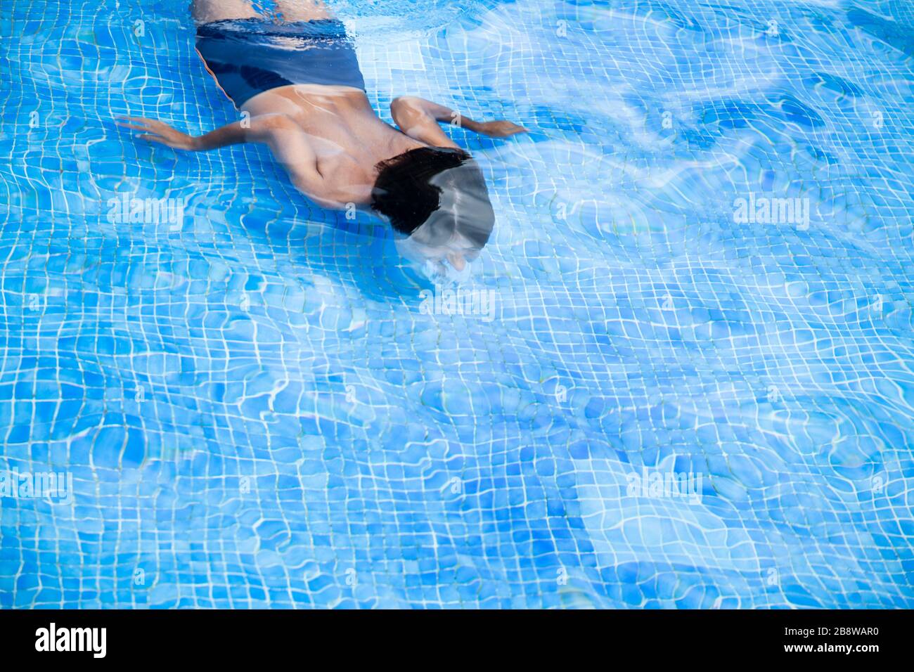 High angle view of boy diving in outdoor swimming pool. Stock Photo