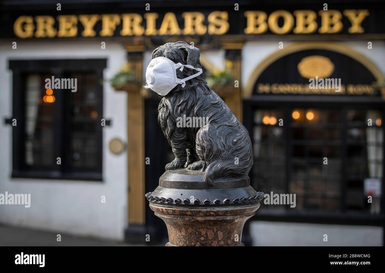 The statue of Greyfriars Bobby in Edinburgh, wears a protective face mask during the coronavirus outbreak. Stock Photo