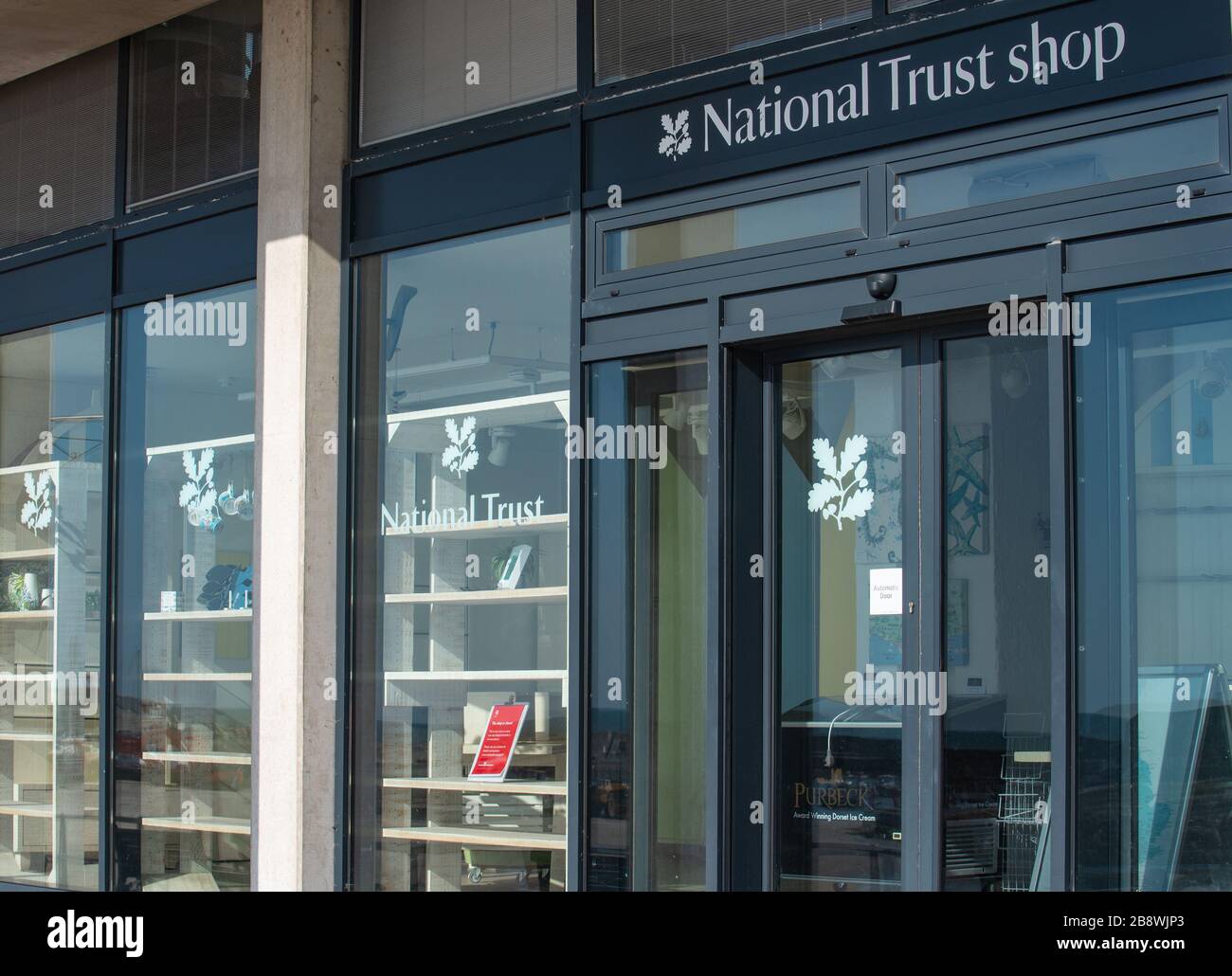 Lyme Regis, Dorset, UK. 23rd Mar, 2020. Corvid-19: The popular National Trust shop at Lyme Regis has closed due to the coronavirus outrbreak. The empty shop makes for a sad sight as the impact of the lock down takes its toll on this and other charitable organisations across the UK. Credit: Celia McMahon/Alamy Live News Stock Photo