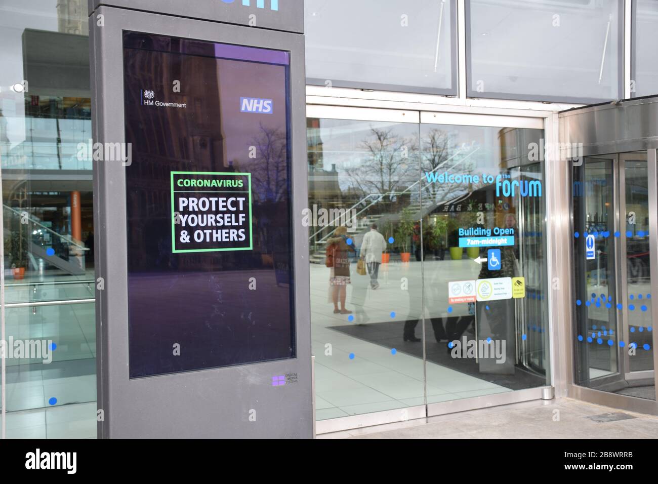 Coronavirus warning information at entrance to The Forum, Norwich UK March 2020 Stock Photo