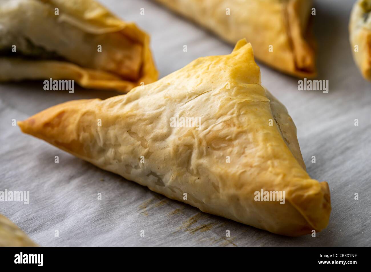 Baked Spanakopita triangles. Stock Photo