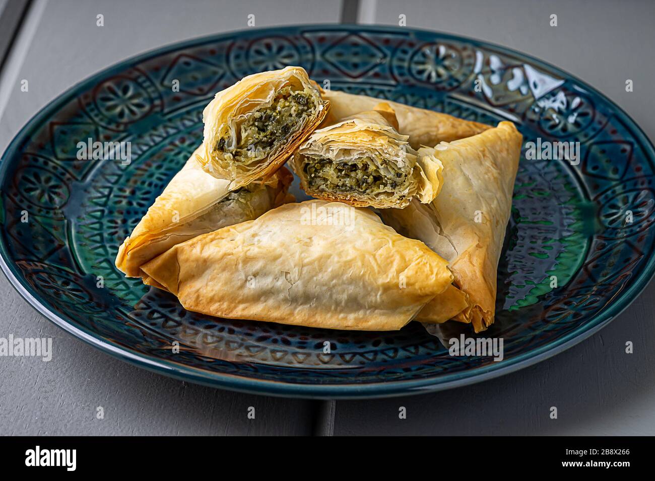 Baked Spanakopita triangles. Stock Photo