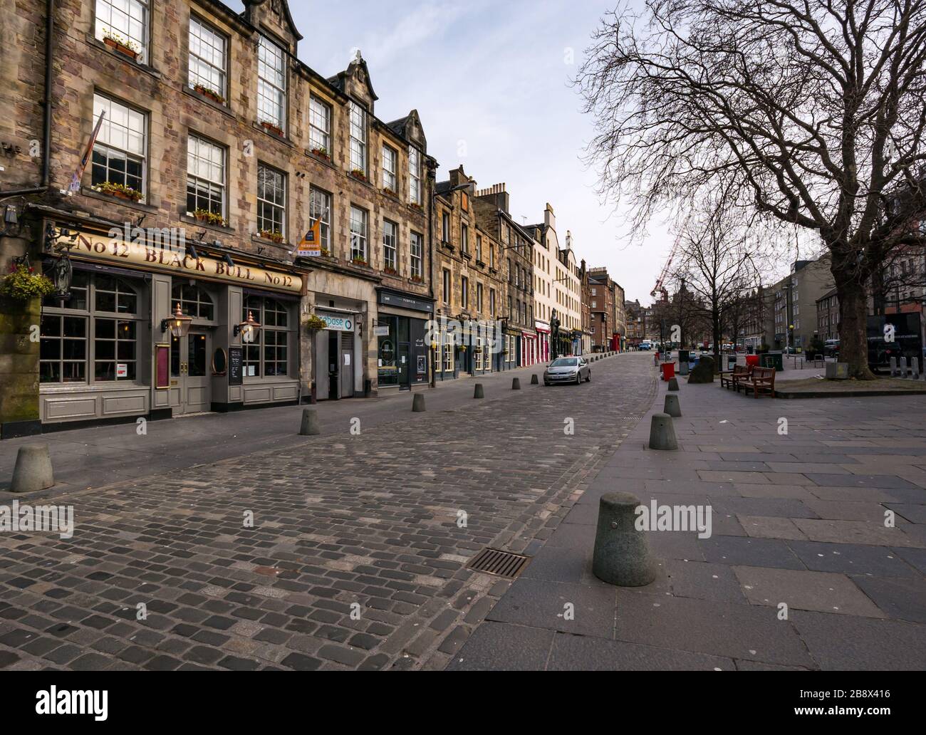 Edinburgh, Scotland, United Kingdom. 23rd March, 2020. Empty streets during the Covid-19 Coronavirus pandemic in the capital city as the message to stay at home heed the social distancing measures appears to have had an effect despite the lovely Spring sunshine. The Grassmarket is completed deserted with all the restaurants and bars closed Stock Photo