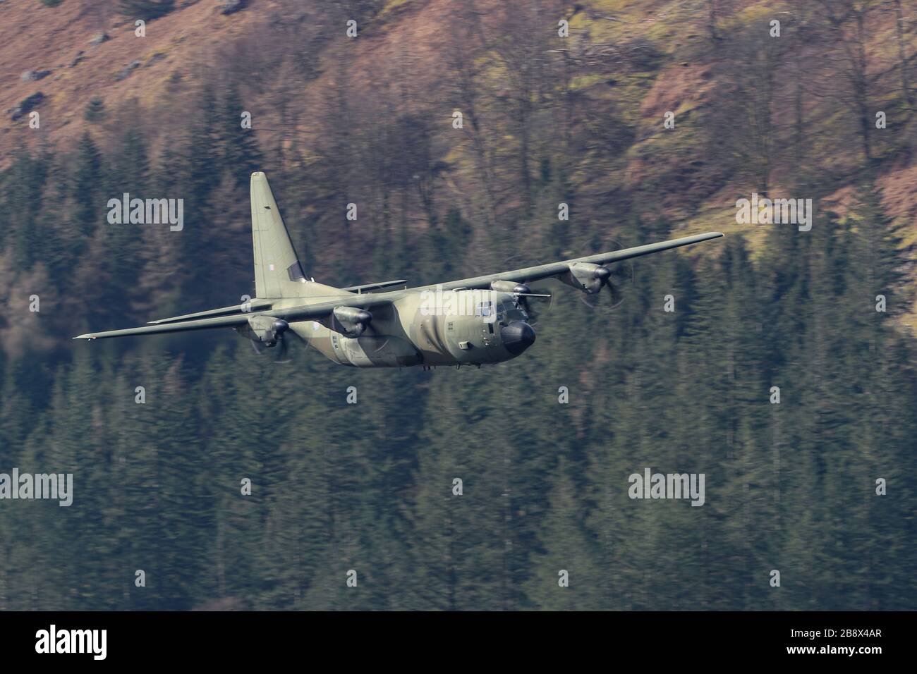 19th March 2020, Thirlmere, Allerdale, Cumbria ; The RAF in Low flying area 17 in full operational training during the corona outbreak : A RAF Lockheed C-130 Hercules in low level training over Thirlmere reservoir in the Lake District Stock Photo