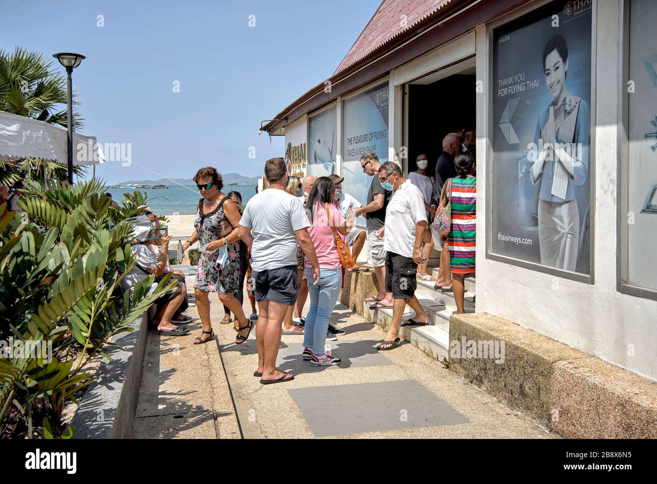 COVID-19 scare. Thailand tourists queueing at the Thai Airways Pattaya booking office anxious to return home fearful of the Corona virus threat Stock Photo