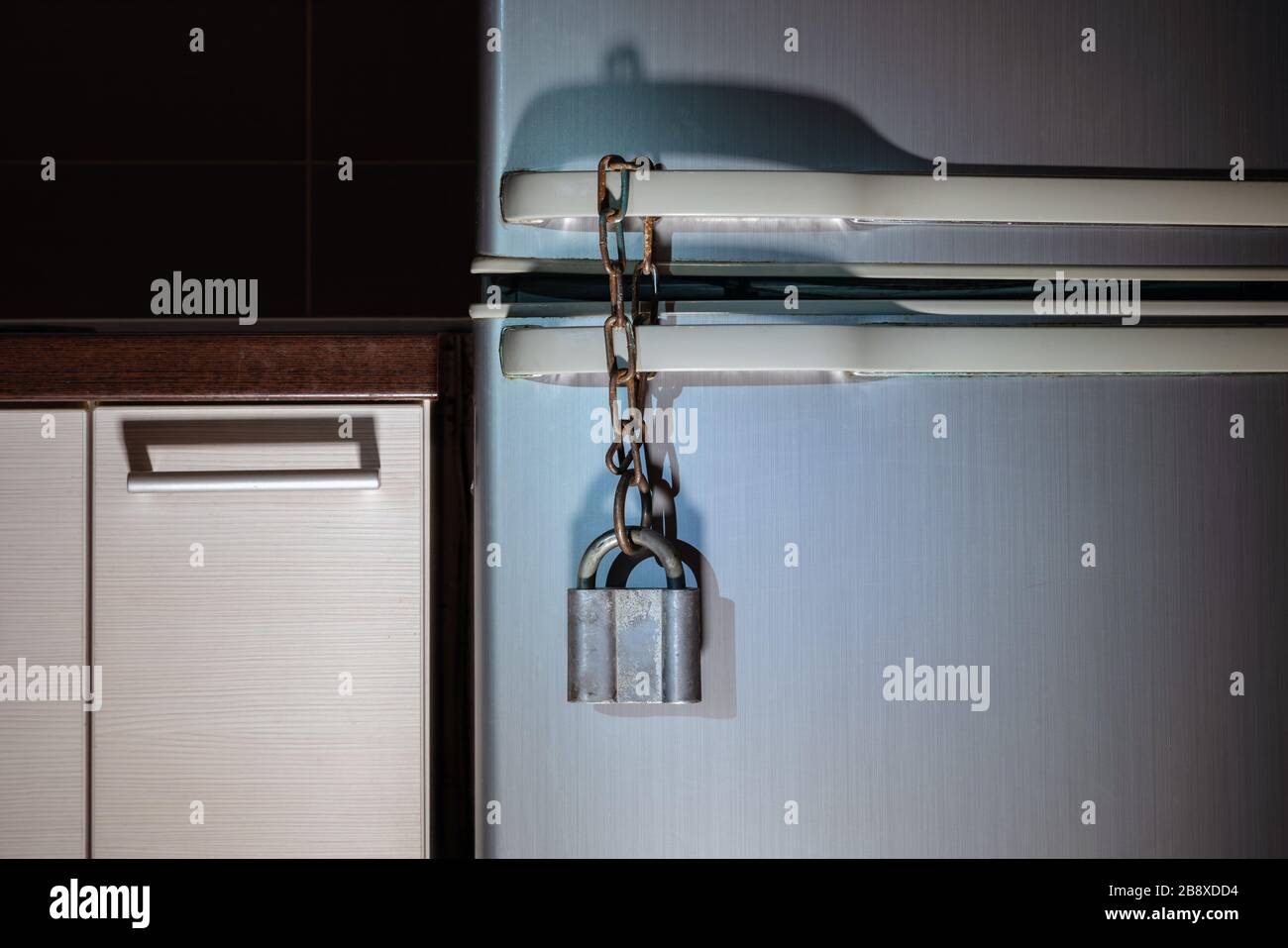 Lock on the fridge. Metal padlock hanging on the refrigerator. Concept