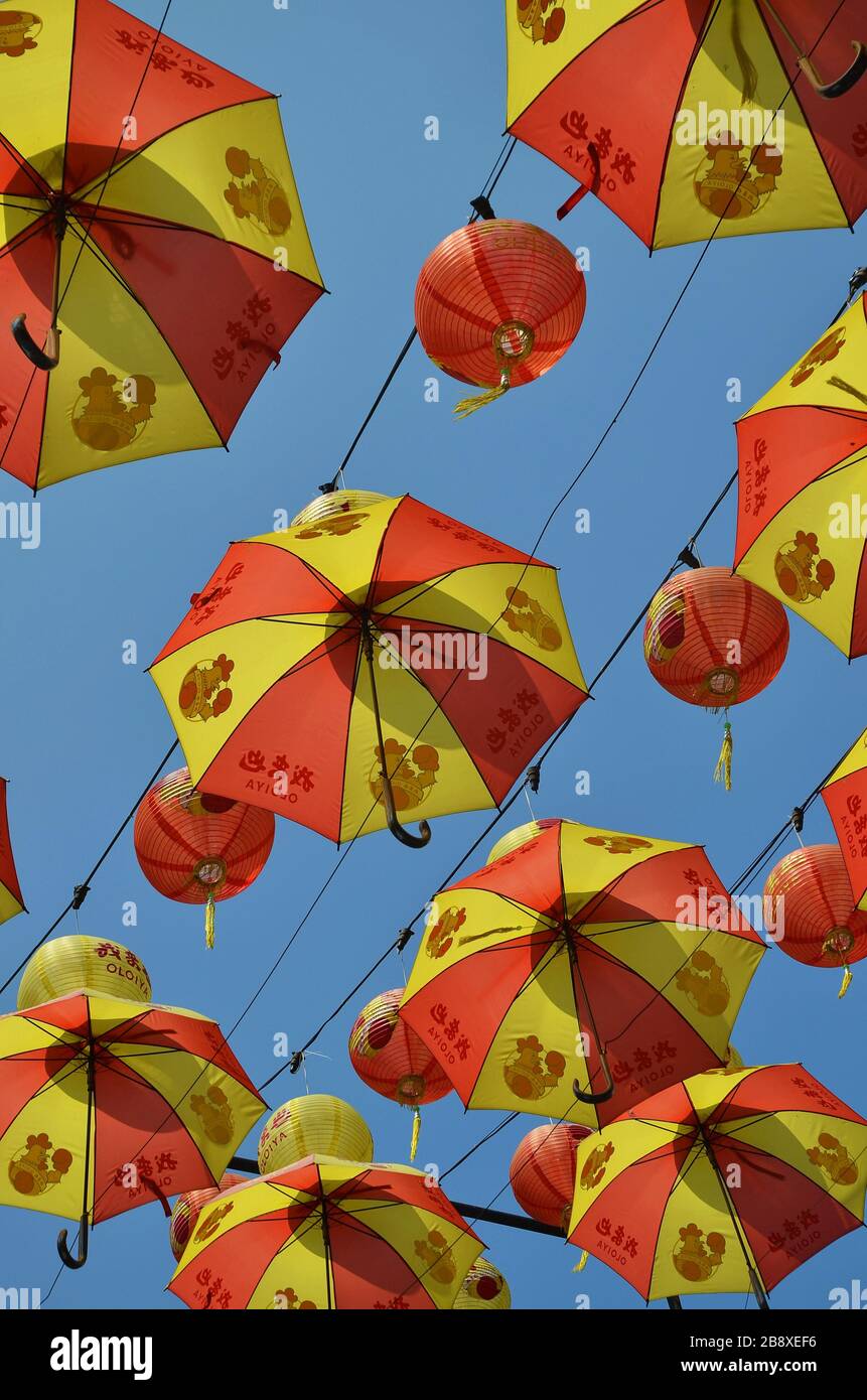 Red and yellow colored umbrellas in blue sky Stock Photo