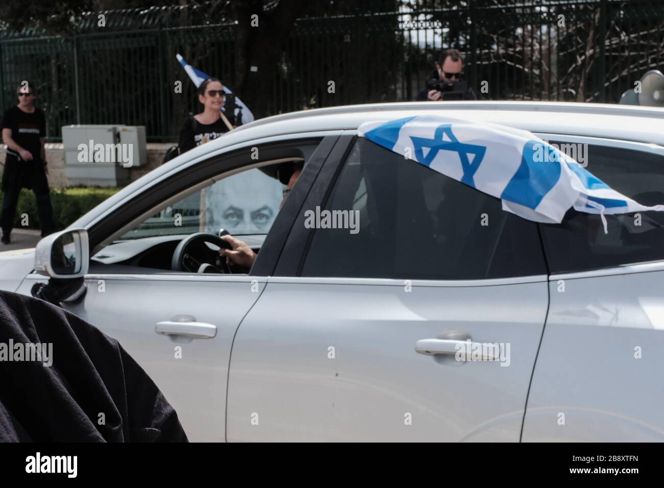 Jerusalem, Israel. 23rd Mar, 2020. The Black Flags Movement brings a convoy of over 1,000 cars to the Knesset, the Israeli Parliament, waving Israeli and black flags, protesting the Netanyahu government's alleged attempt to manipulate legislation and abuse Coronavirus emergency measures in an attempt to ‘hijack' democracy for political and personal benefits. A Supreme Court appeal is now underway aiming to restore the full powers of Parliament, blocked from functioning by Knesset Speaker, Edelstein, a Netanyahu ally. Credit: Nir Alon/Alamy Live News Stock Photo