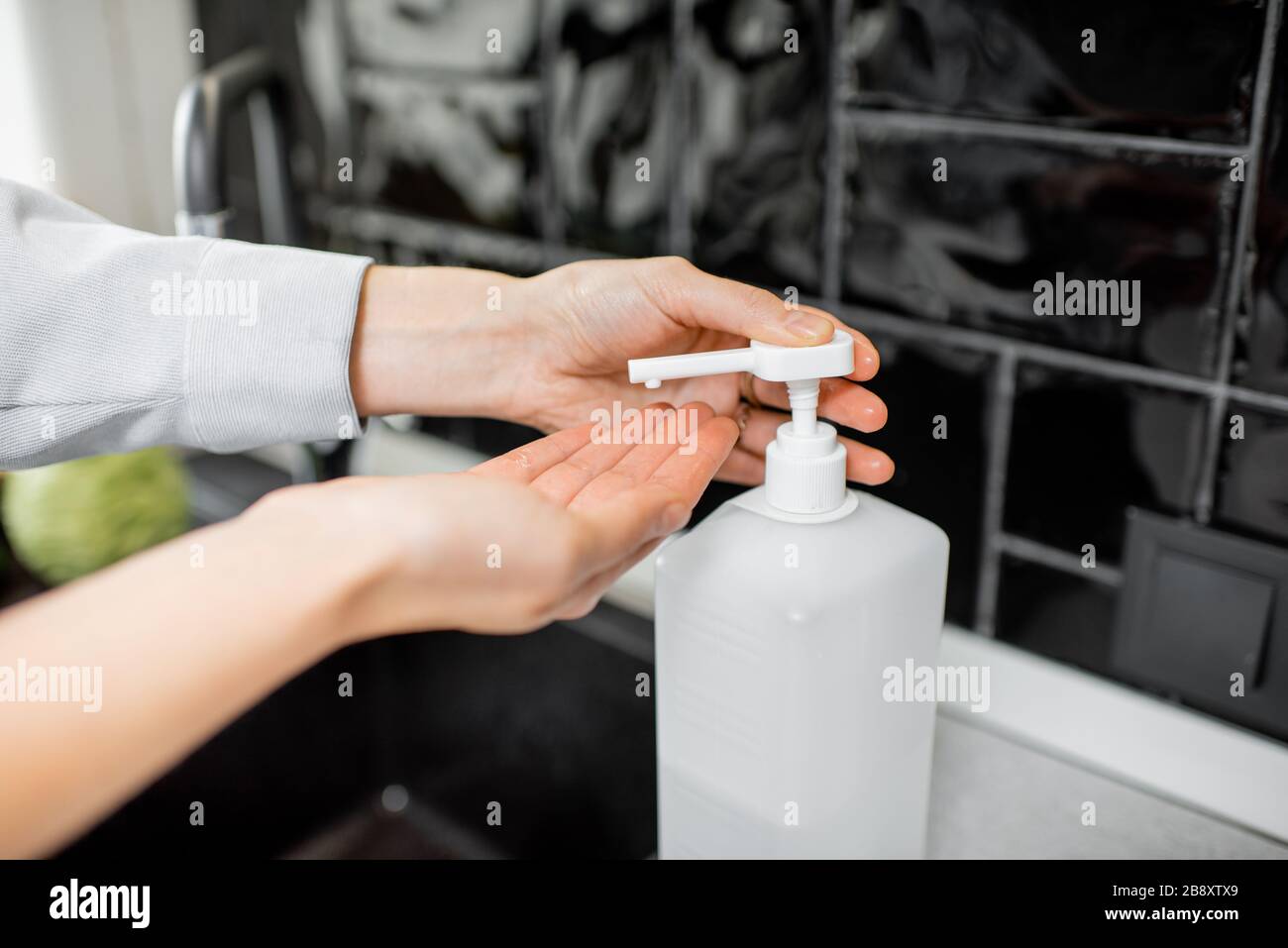 Woman applying detergent on hands while washing vegetables at home