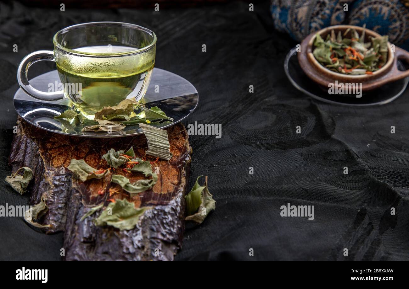 A Cup of pandan leaf tea, indian marsh fleabane plant leaves with Safflower dried (Saffron substitute) at dark background. Thai herbal plant and healt Stock Photo
