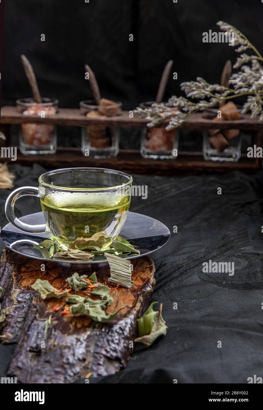 A Cup of pandan leaf tea, indian marsh fleabane plant leaves with Safflower dried (Saffron substitute) at dark background. Thai herbal plant and healt Stock Photo