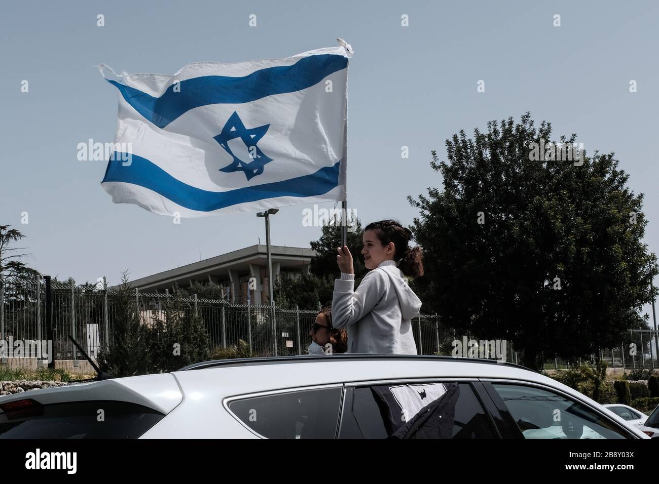 Jerusalem, Israel. 23rd Mar, 2020. The Black Flags Movement brings a convoy of over 1,000 cars to the Knesset, the Israeli Parliament, waving Israeli and black flags, protesting the Netanyahu government's alleged attempt to manipulate legislation and abuse Coronavirus emergency measures in an attempt to ‘hijack' democracy for political and personal benefits. A Supreme Court appeal is now underway aiming to restore the full powers of Parliament, blocked from functioning by Knesset Speaker, Edelstein, a Netanyahu ally. Credit: Nir Alon/Alamy Live News Stock Photo