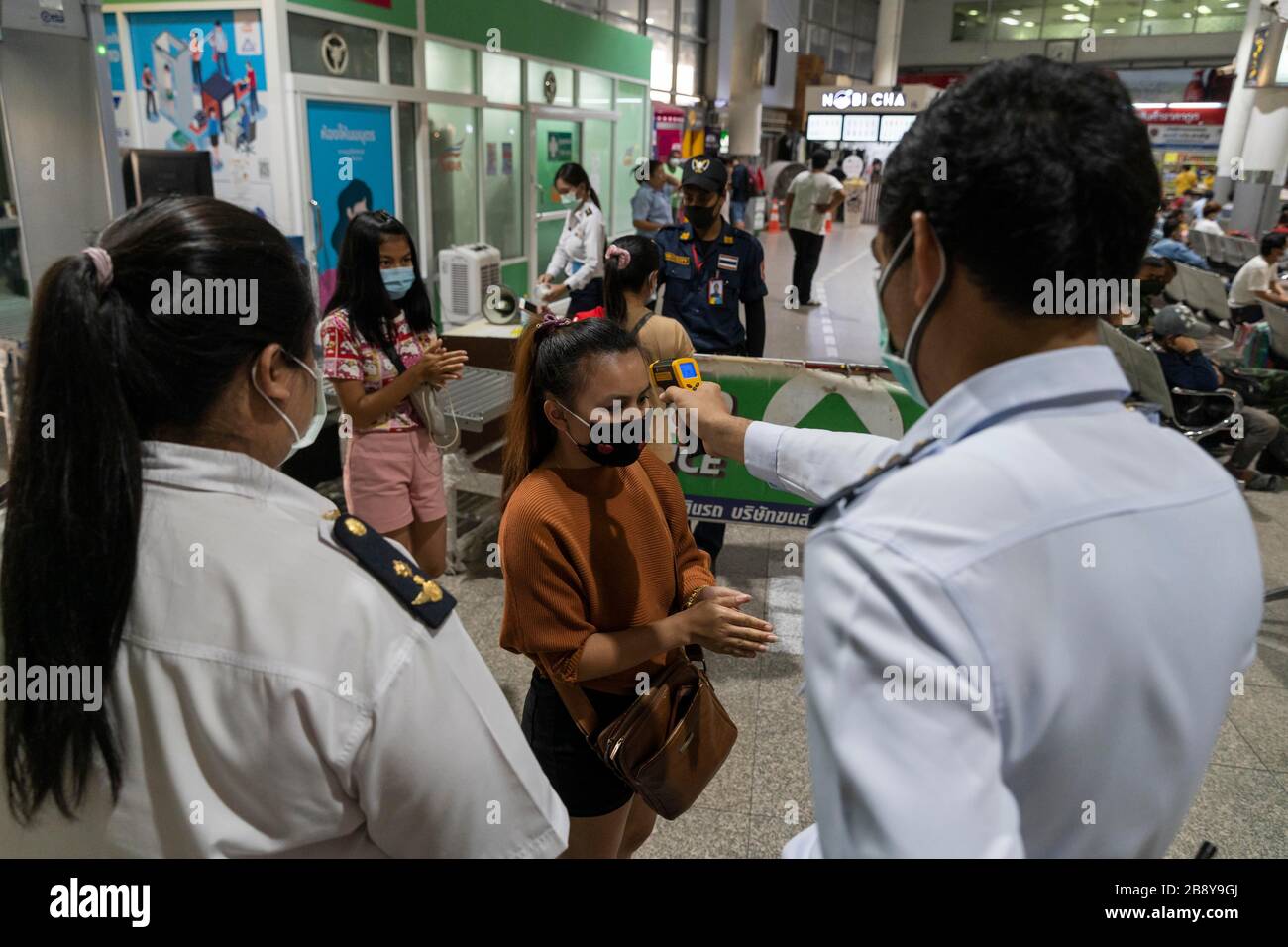 Bangkok, Bangkok, Thailand. 23rd Mar, 2020. A member of the public undergoes a temperature check before entering Bangkok's Mochit bus terminal. The travel hub was filled with thousands of travelers heading back to their home provinces after the city government ordered the mandatory closure of many nonessential businesses on March 22nd, 2020 in an effort to slow the spread of the Covid-19 virus. Large portions of the capital's workforce live paycheck to pay check, making staying in the city financially impossible due to their sudden lack of employment. Credit: ZUMA Press, Inc./Alamy Live News Stock Photo