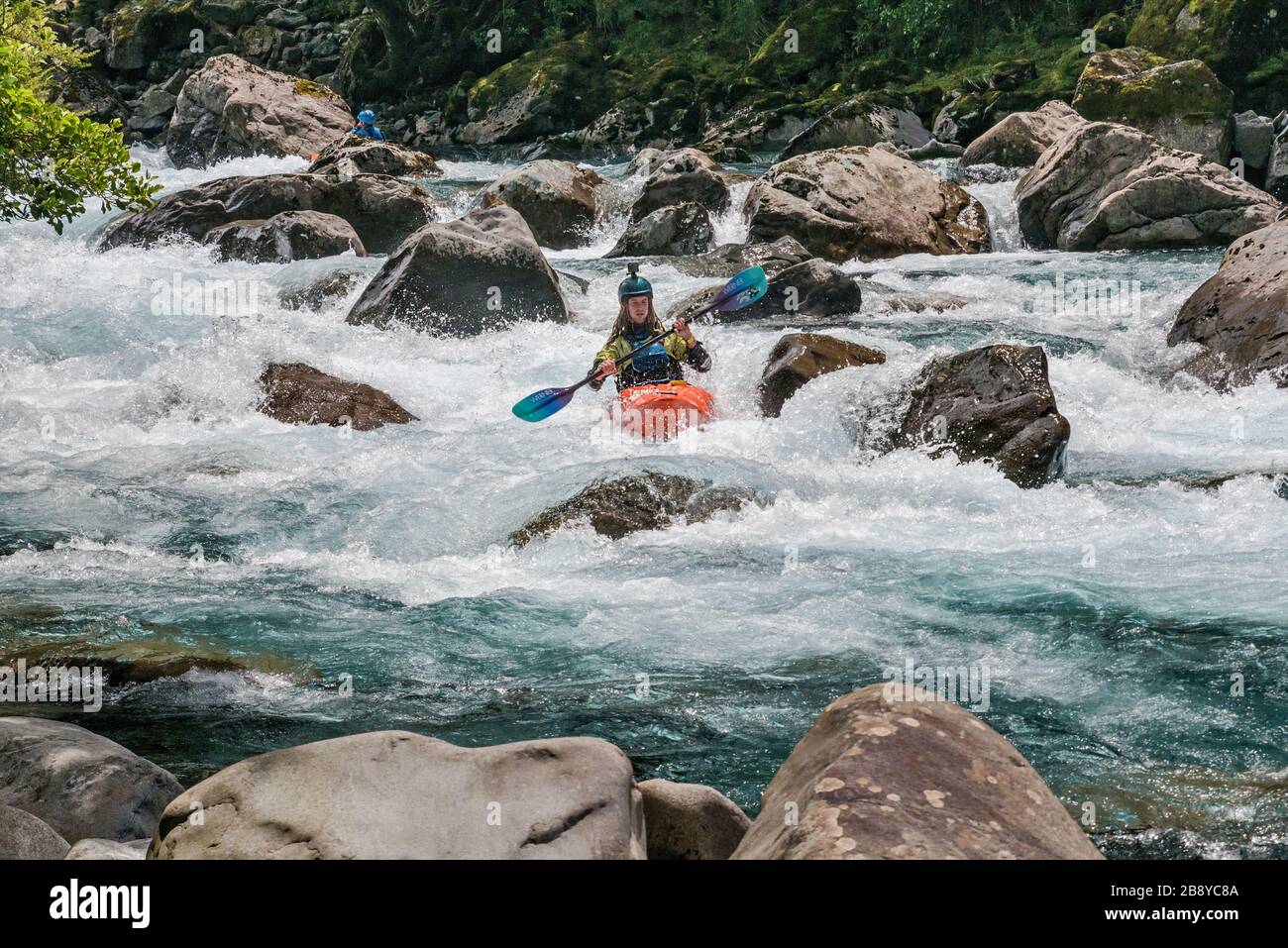 Kayaker at Hollyford River rapids, Fiordland National Park, near Milford Sound, Southland Region, South Island, New Zealand Stock Photo