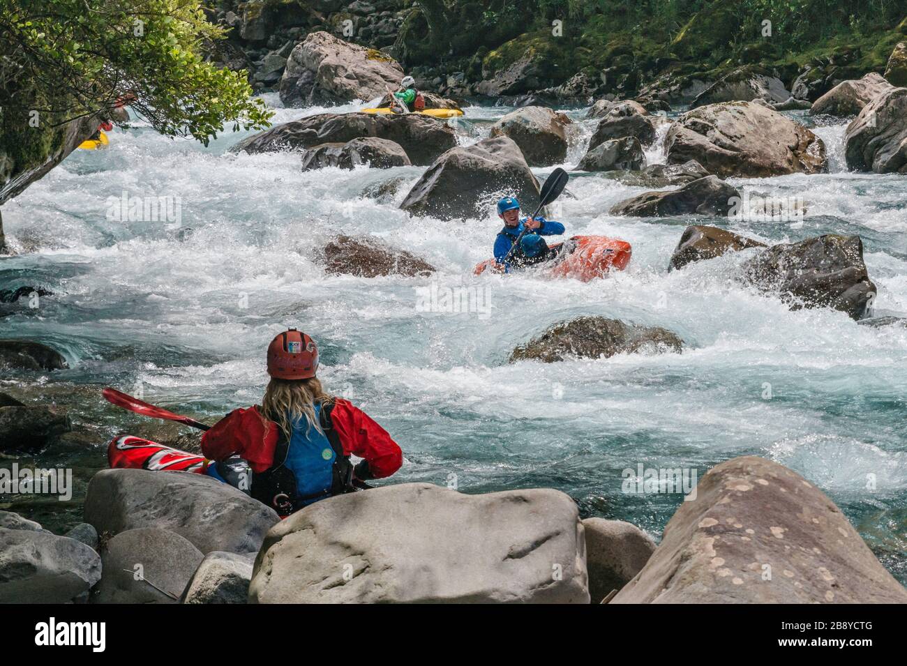 Kayakers at Hollyford River rapids, Fiordland National Park, near Milford Sound, Southland Region, South Island, New Zealand Stock Photo