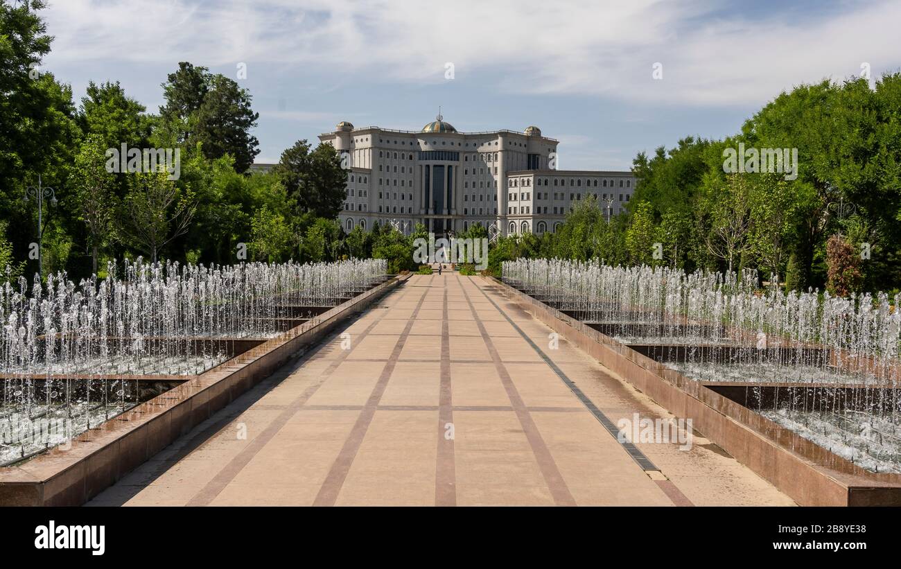 Dushanbe, Tazjikistan - June 14, 2019: Rudaki Park with trees, fountain and National Library in the capital of Dushanbe. Stock Photo