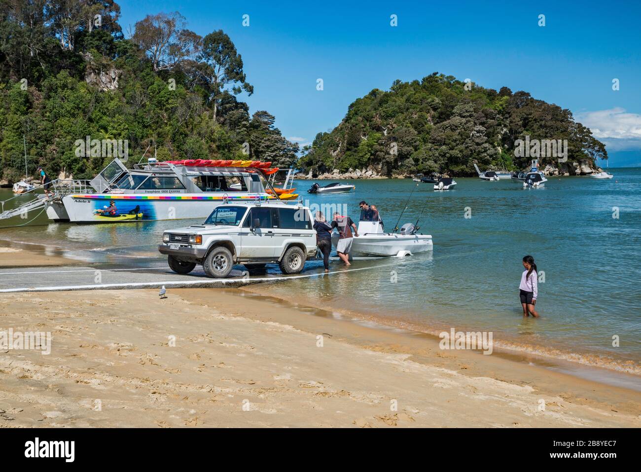 Kaka Ramp Vehicle pulling out boat at ramp, Kaiteriteri Beach over Tasman Bay ...